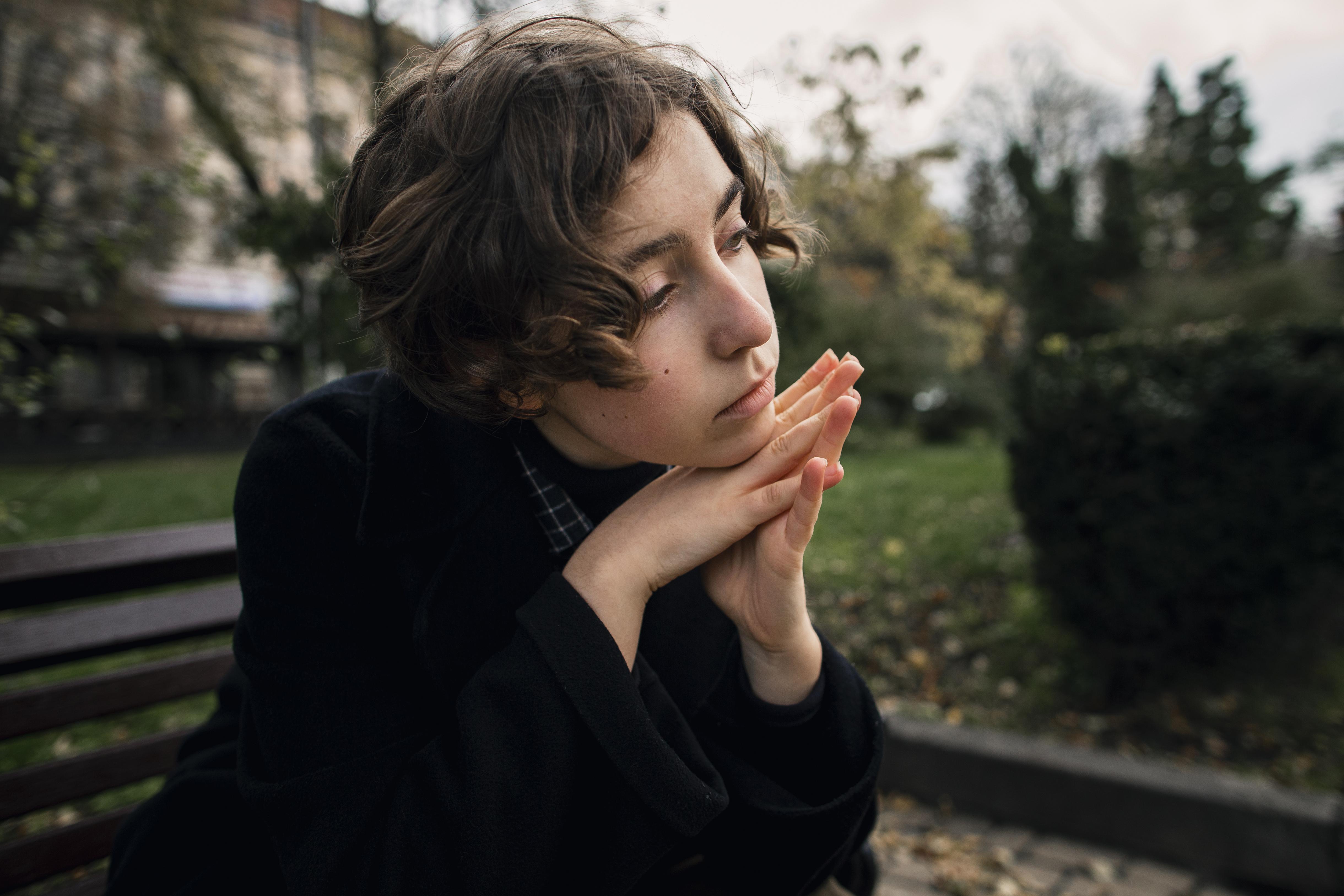 Thoughtful person sitting on a bench